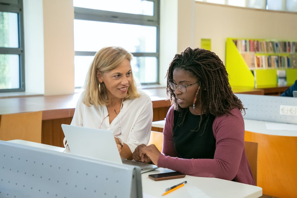 Two people using a laptop