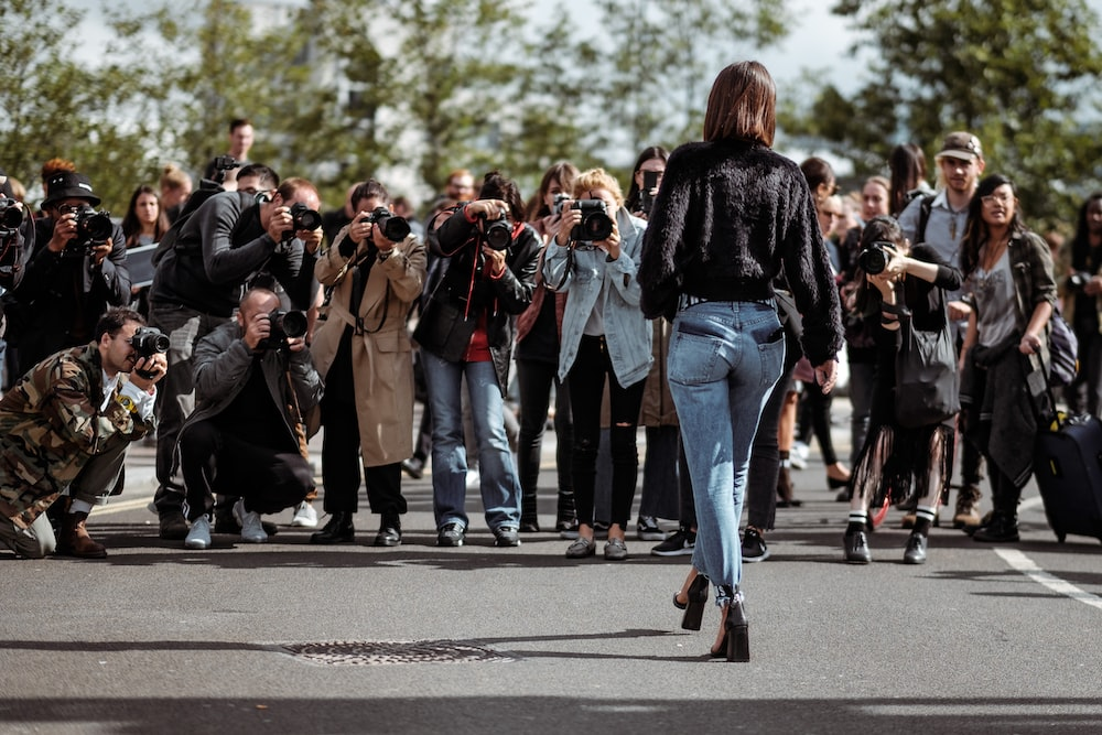 A celebrity posing in front of paparazzi