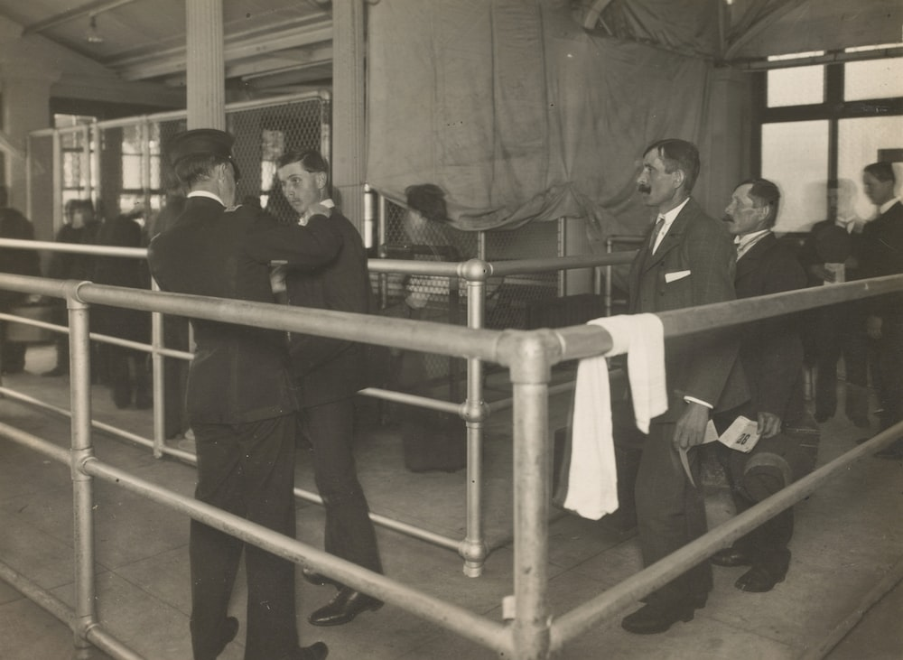 A grey-scale photograph of Ellis Island inspections 