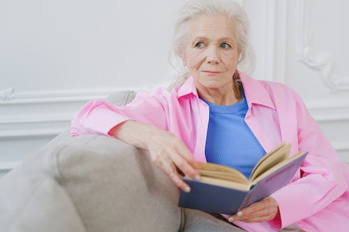An elderly person with a book in their hand  