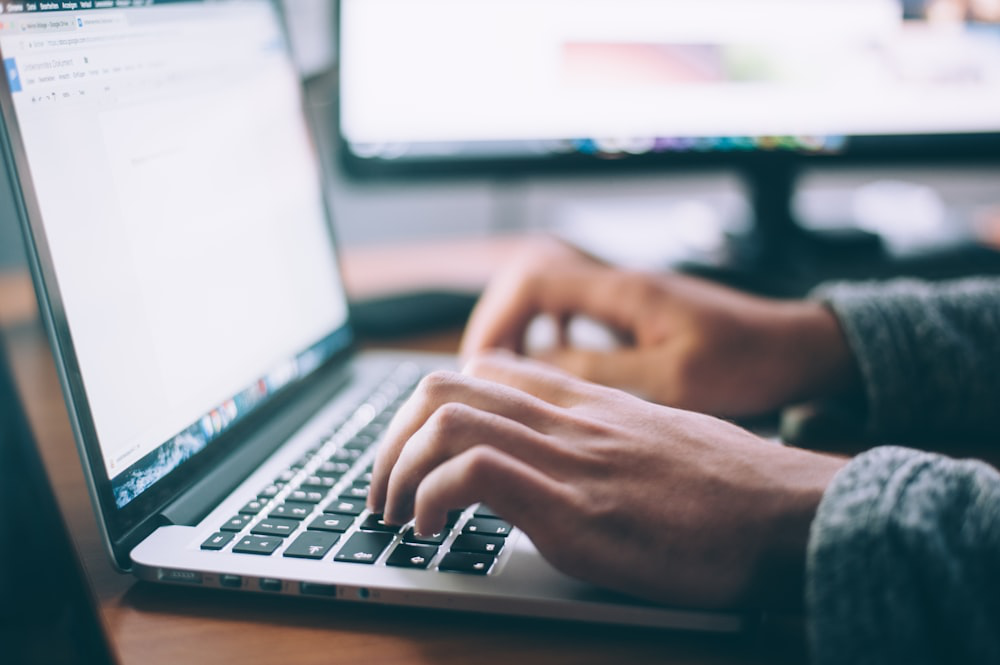 a person typing on their computer.