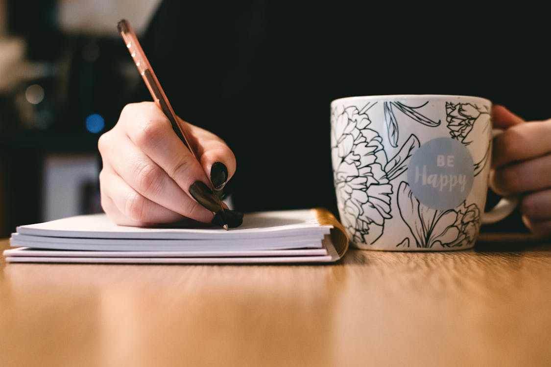 a person writing at their desk.