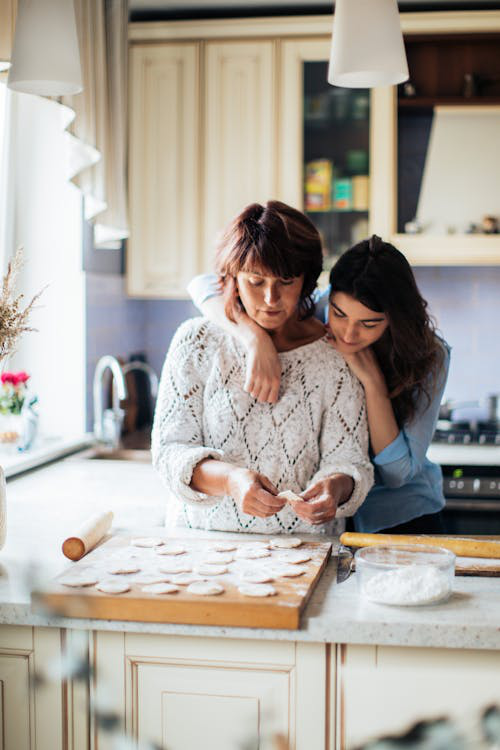 a mother and daughter standing together.