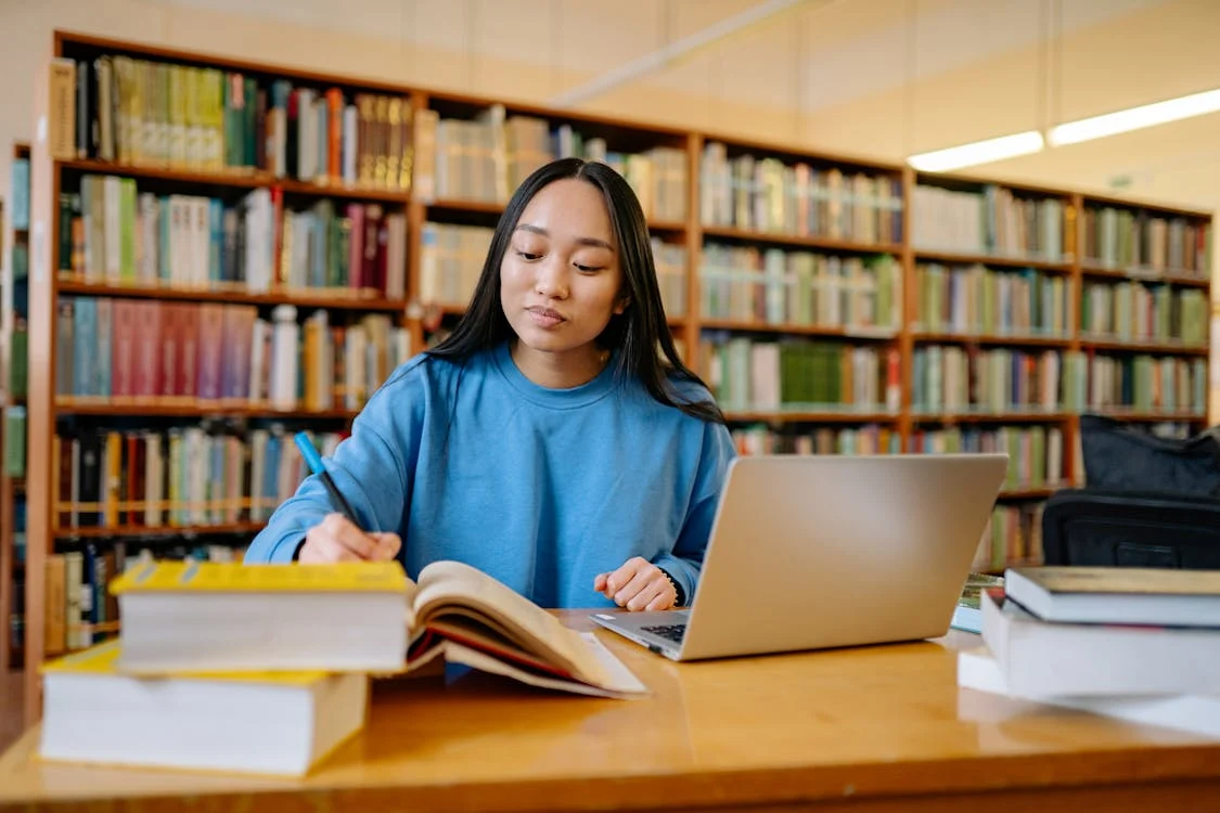 a woman in a blue shirt taking notes.