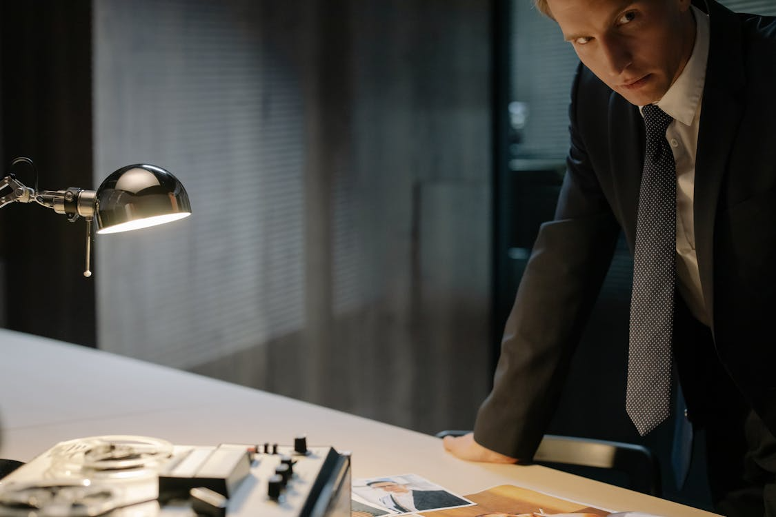 a man in a coat leaning over a desk.