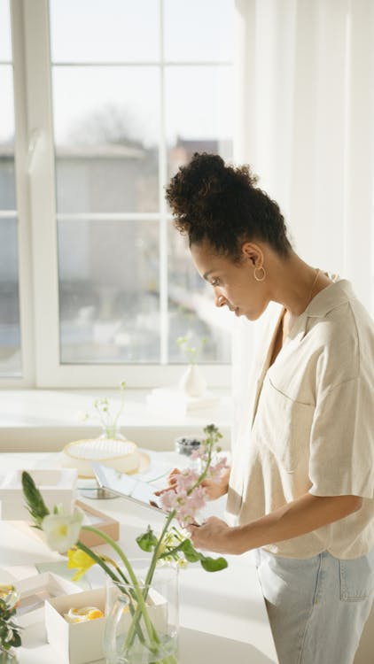 a woman standing next to flowers.