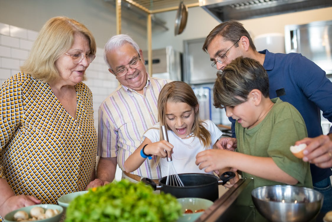 a family in the kitchen cooking together.