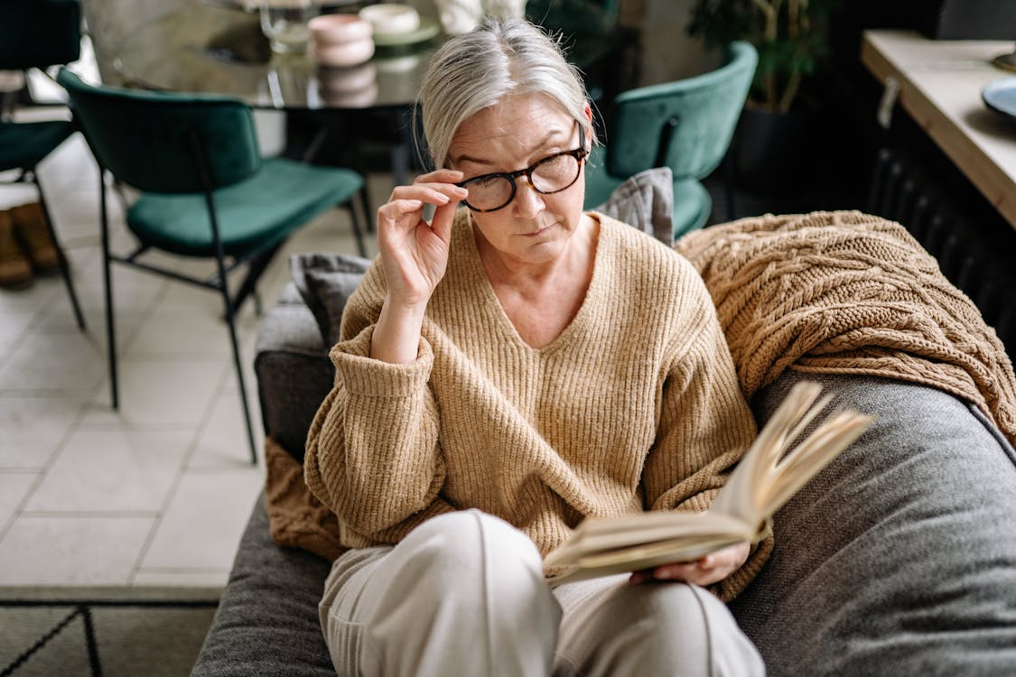 a woman in a brown sweater sitting on the couch.