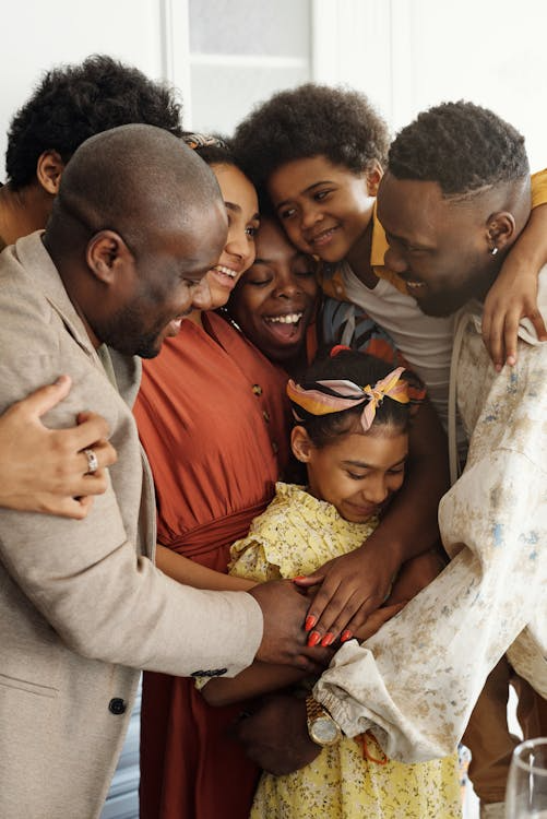 a family in a group hug in the kitchen.