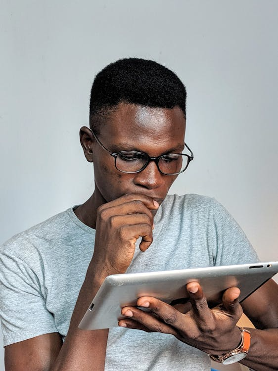 a man in a gray shirt holding an iPad.