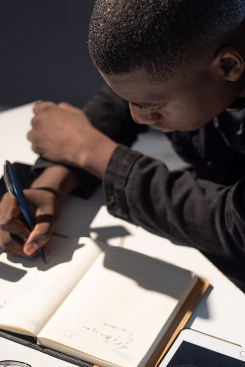 a man writing in a notebook.