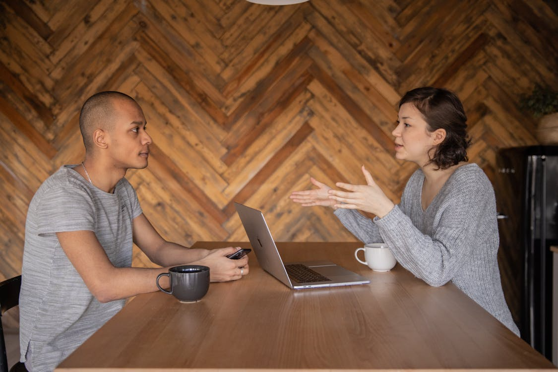 two people sitting and having a conversation.