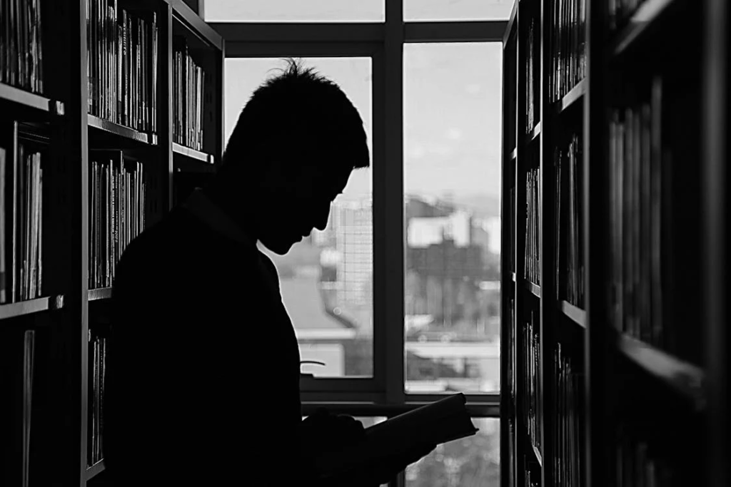 a man standing at the library by the window.