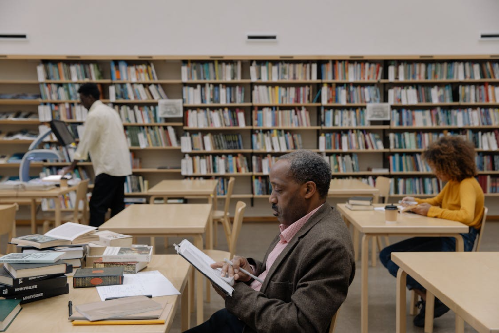 a man sitting at the library holding a book.