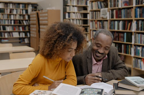 two people going through books at the library