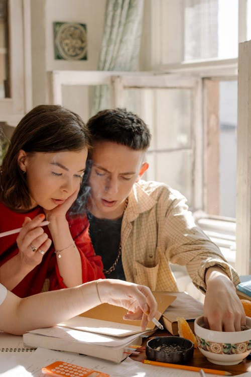 two people sitting at a desk and going over some studies.