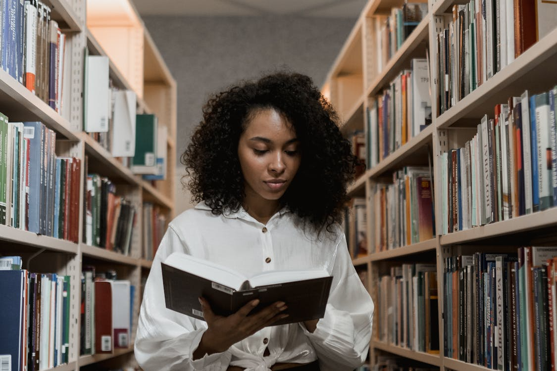 a woman in a white blouse holding a book.