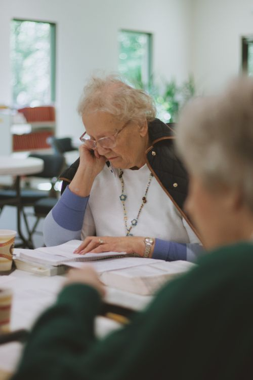 an elderly woman looking at a book.