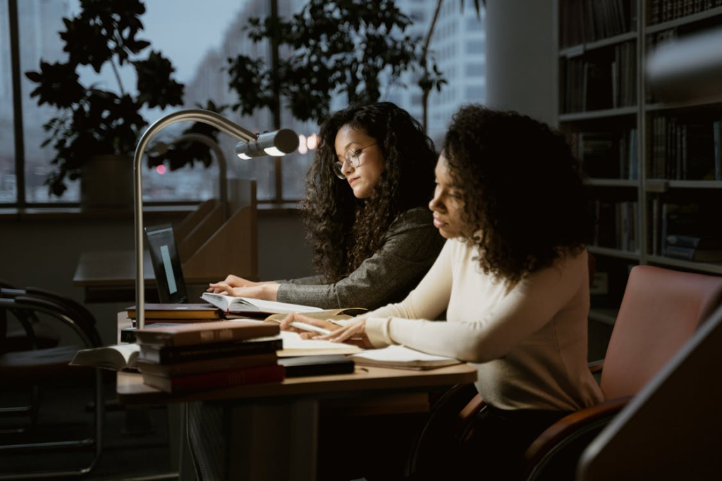 two women sitting together at the library.