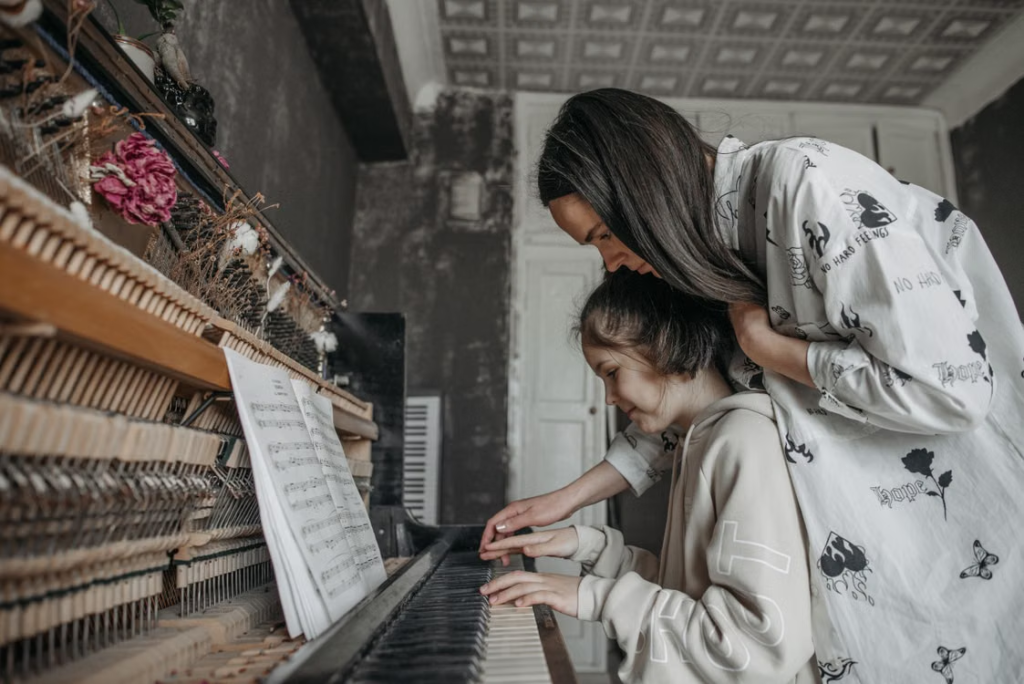 a girl getting a piano lesson.